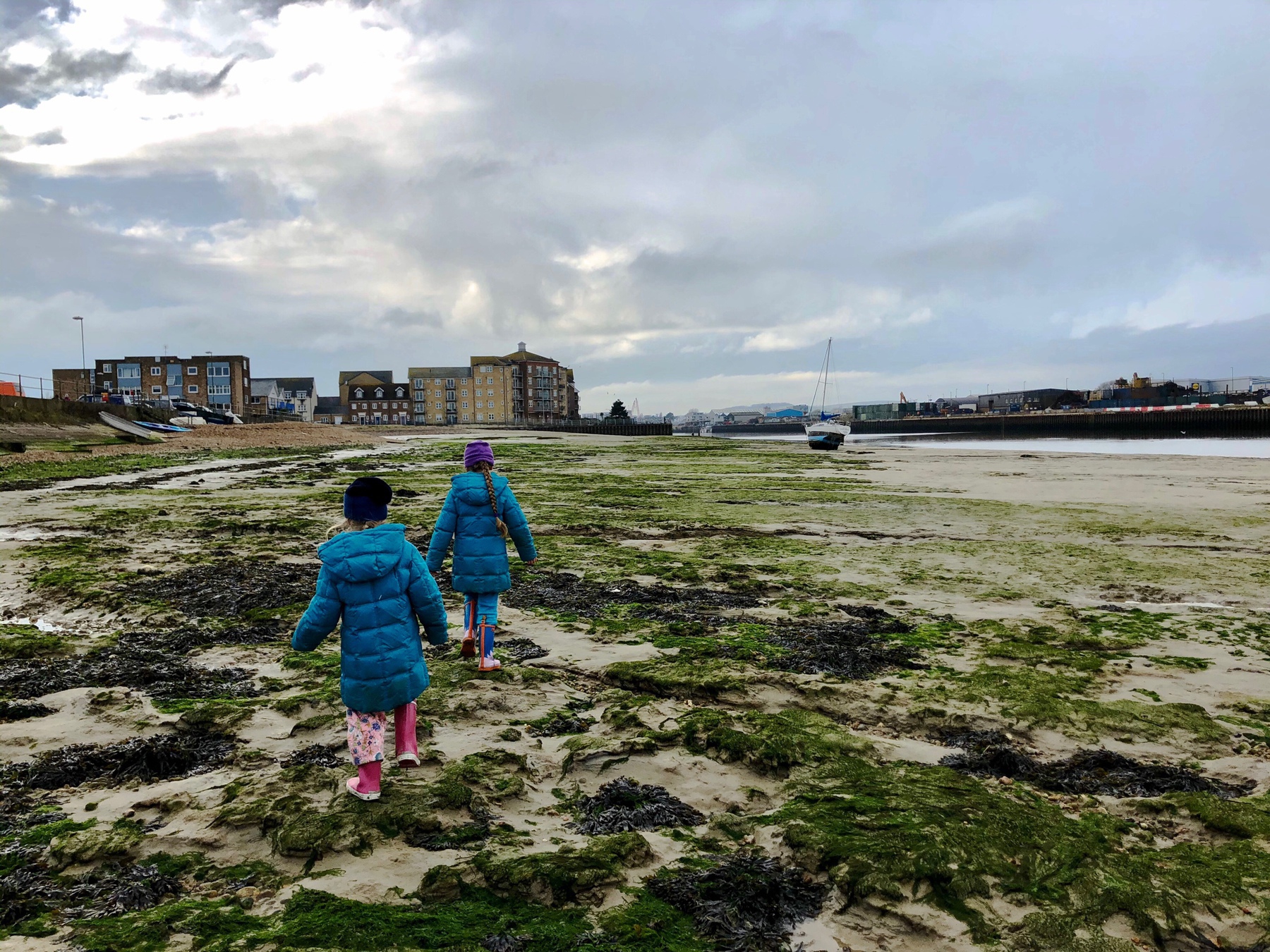 Two girls walking in the Adur at low tide. 