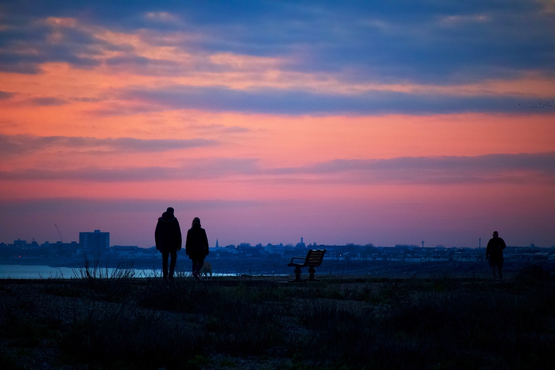 Dusk over Shoreham Beach, looking towards Worthing, with walkers in the foreground