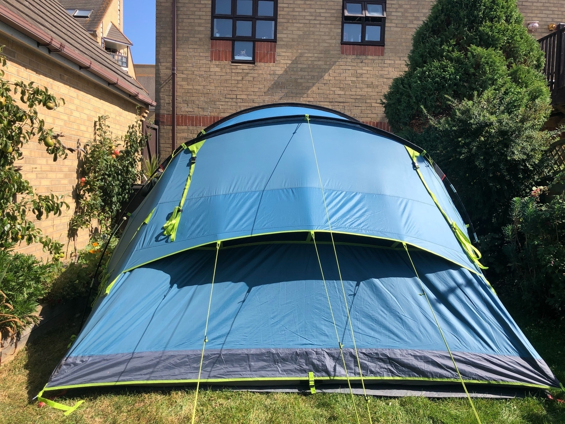 A tent pitched jn a back garden. 