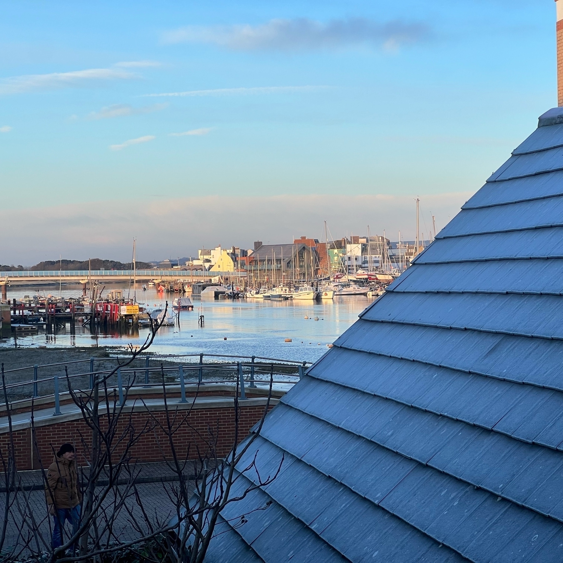 A frosty roof with the sunlit river Adur in the background.