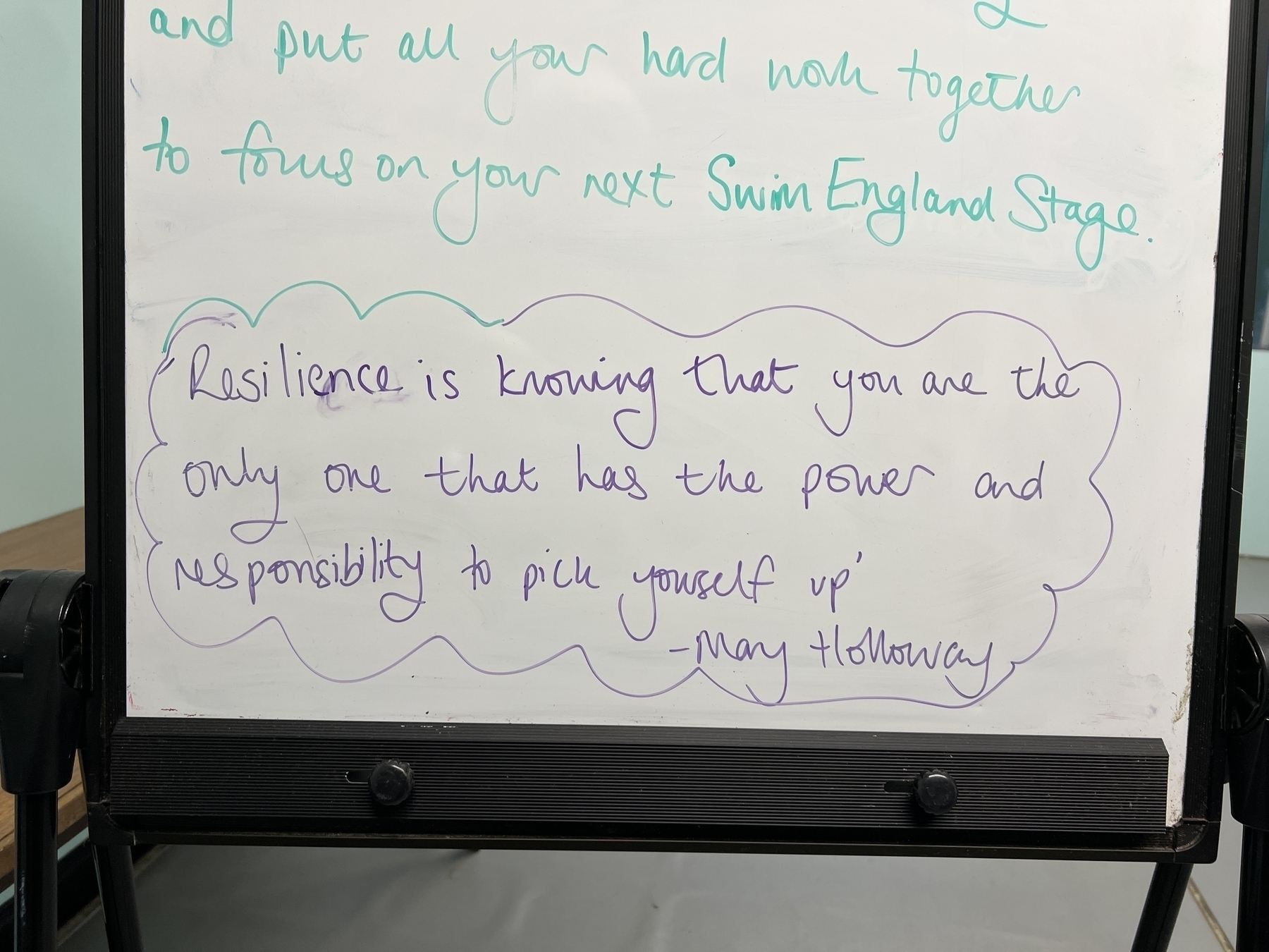 A whiteboard with the following written on it: “Resilience is knowing that you are the only one that has the power and responsibly to pick youself up&10;- May Holloway”