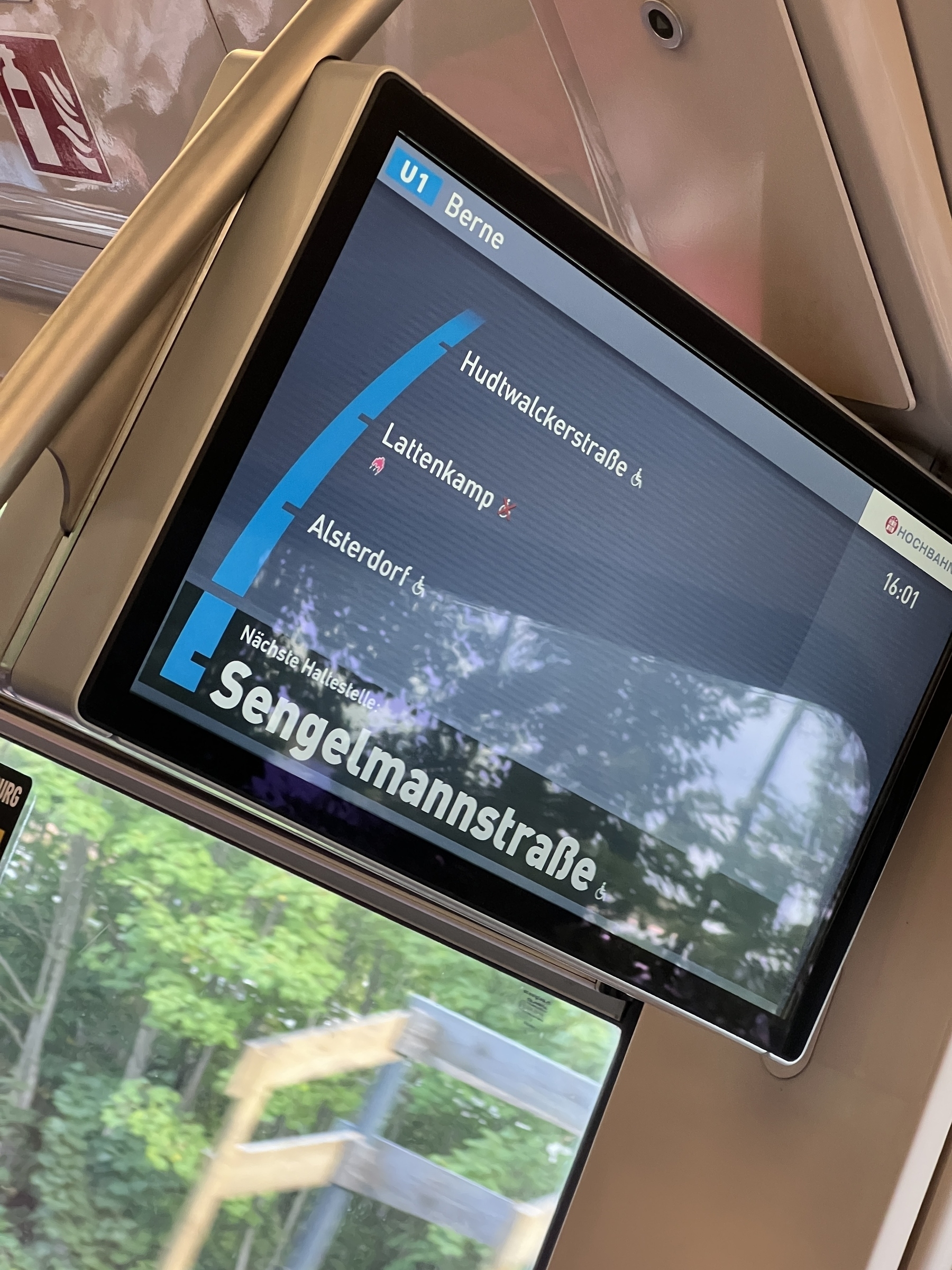 A digital display inside a train shows current and upcoming station information for the U1 line, with the next stop being Sengelmannstraße.