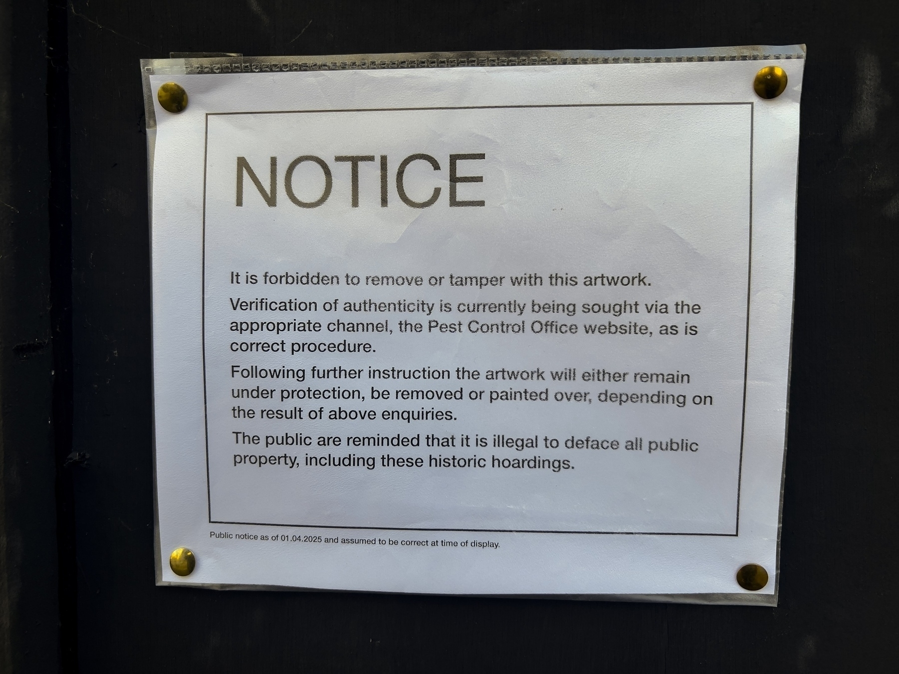 A notice forbids tampering with artwork, mentions verification processes, and reminds the public not to deface property. It is clearly satire. 