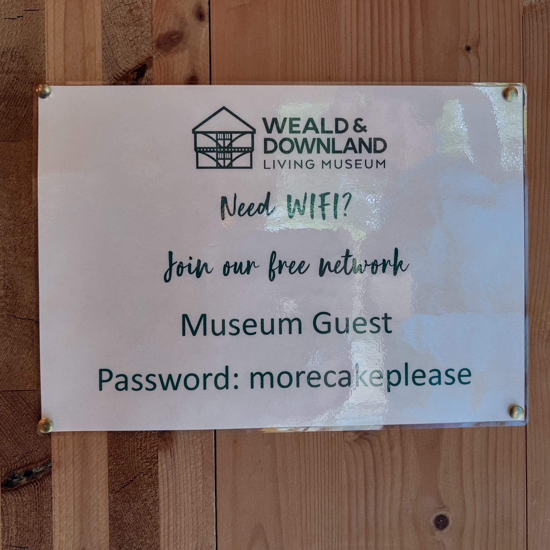 A sign provides WiFi information for "Weald & Downland Living Museum" with the network name "Museum Guest" and password "morecakeplease."
