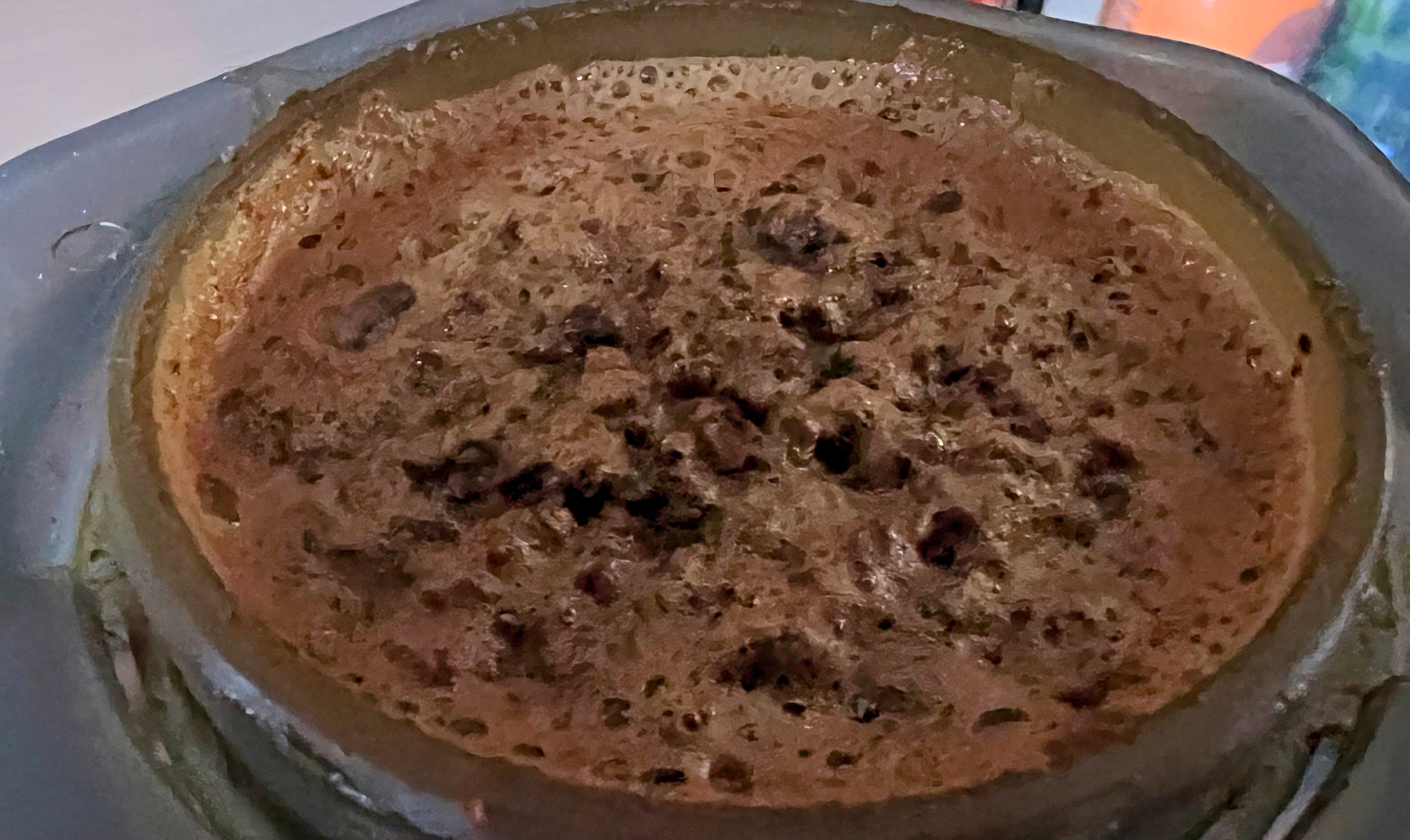 A close-up view of coffee brewing in an aeropress in the inverted position. 